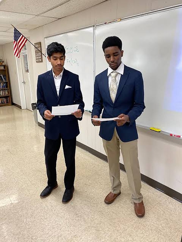 Two students practicing their speeches in a classroom at a partner school
